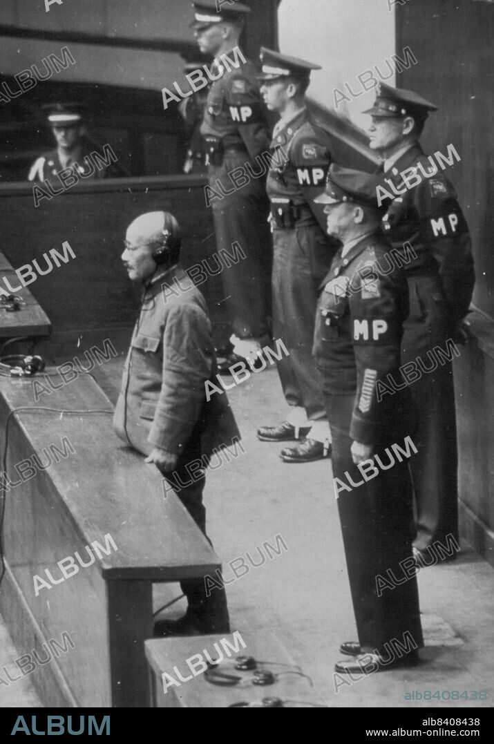 Sentence Passed -- Hideki Tojo, former Prime Minister of Japan and war leader stands alone in dock as his sentence is read by the International Military Tribunal, Far East in Tokyo Nov. 12. At rear is Lt. Col. S.Kenworthy, who is responsible for the prisoners. November 29, 1948. (Photo by Associated Press Photo).