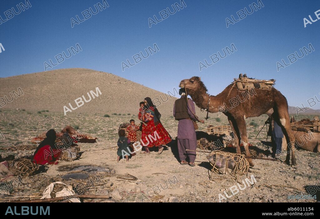 AFGHANISTAN Nomadic LIfestyle Nomad family with camel preparing to move.