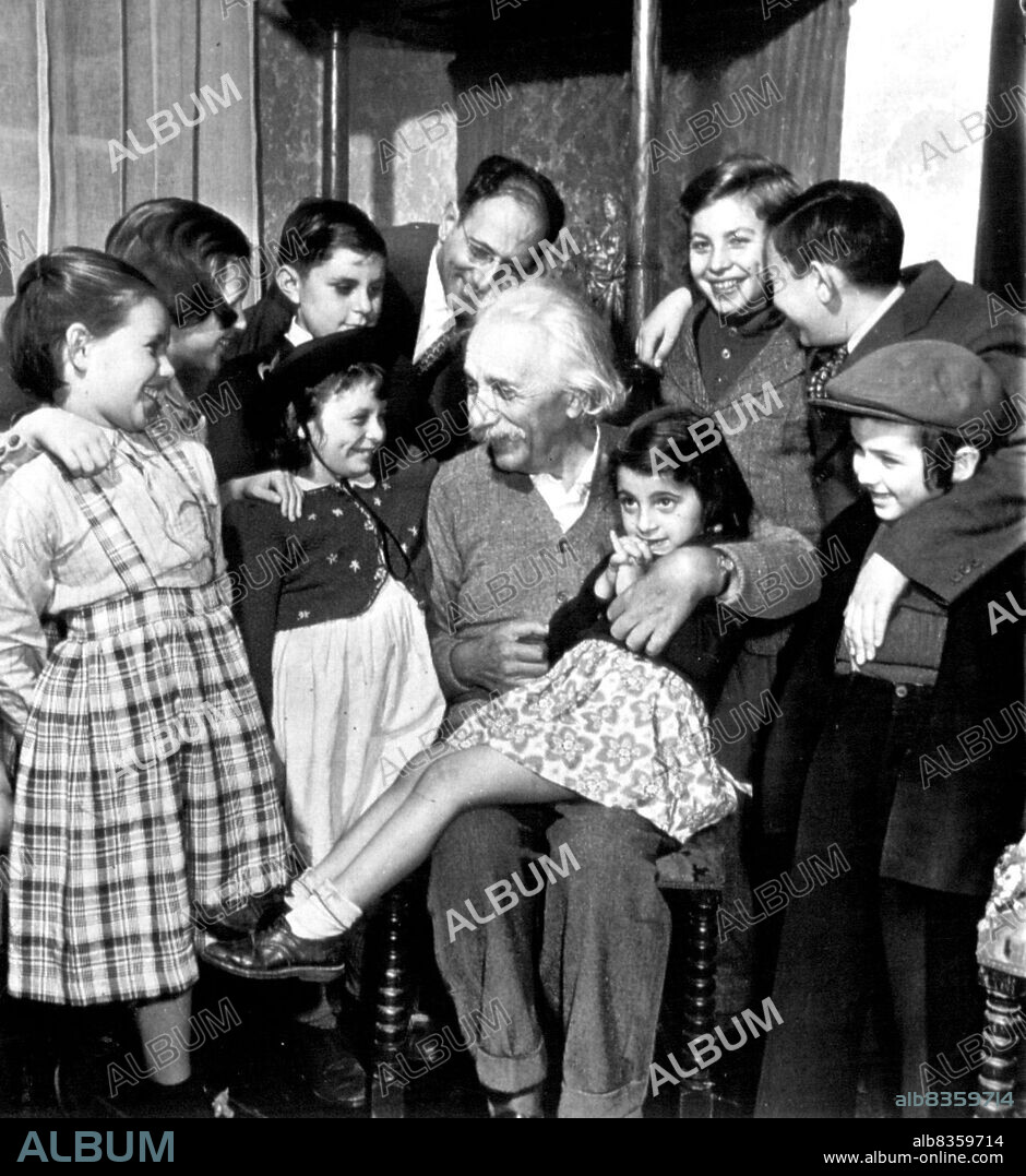 Displaced Children Visit Einstein -- DP youngsters, recently arrived from Europe, pay a pre-birthday call on Prof. Albert Einstein at his home here Thursday. The famous scientist will be 70 years old tomorrow. Leonora Aragones, 5, occupier his lap. Spokesman for the group was Elizabeth Kerzek (second from left), 11, a cousin of Dr. Einstein who met him for first time. Children are from Reception Shelter of United Service for New York City. March 13, 1949. (Photo by AP Wirephoto).