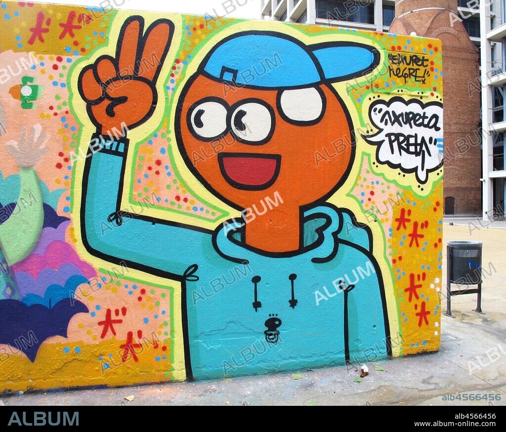 Pintura en aerosol de joven estilo comic con gorro y haciendo la v de la victoria con una mano, graffiti mural, Plaza Tres Chimeneas, Poble Sec, distrito Sants Montjuit, Barcelona en 2016.