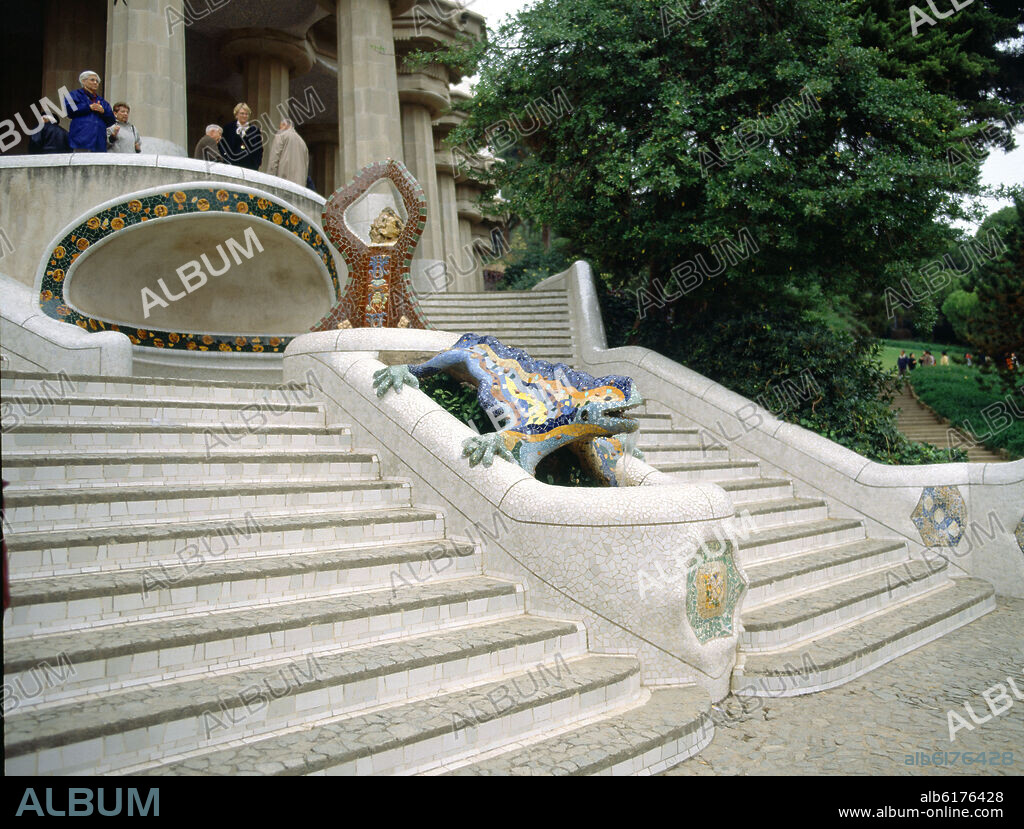 ANTONI GAUDÍ. ESCALINATA DEL PARQUE GÜELL DE DOBLE RAMPA DECORADA CON UN LAGARTO O DRAGON MULTICOLOR Y UN TRIPODE - 1900/1914.
