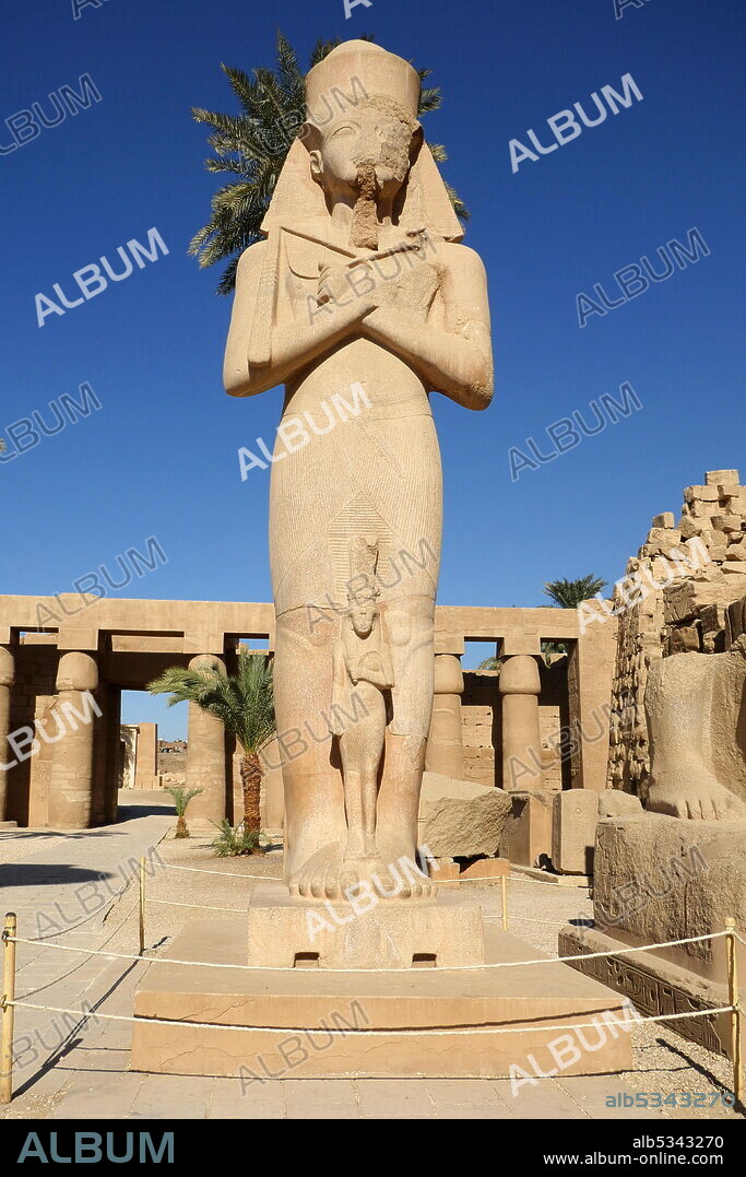 Statue of Pinedjem I; High Priest of Amun at Thebes in Ancient Egypt from 1070 to 1032 BC and the de facto ruler of the south of the country from 1054 BC. Karnak Temple Complex, in Luxor, Egypt. Construction at the complex began during the reign of Senusret I in the Middle Kingdom and continued into the Ptolemaic period, although most of the extant buildings date from the New Kingdom. The area around Karnak was the main place of worship of the eighteenth dynasty Theban Triad with the god Amun as its head. It is part of the monumental city of Thebes..