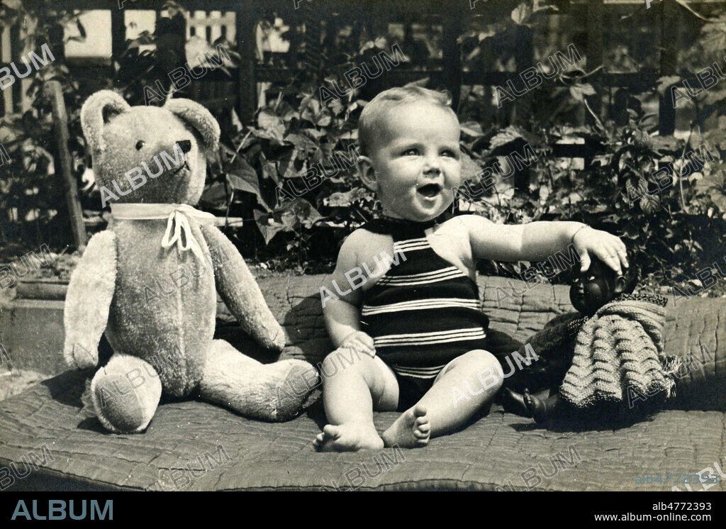 Bebe avec un ours en peluche et une poupee d'enfant noir. Photographie anonyme vers 1930. Credit : Jean Vigne/KHARBINE-TAPABOR.