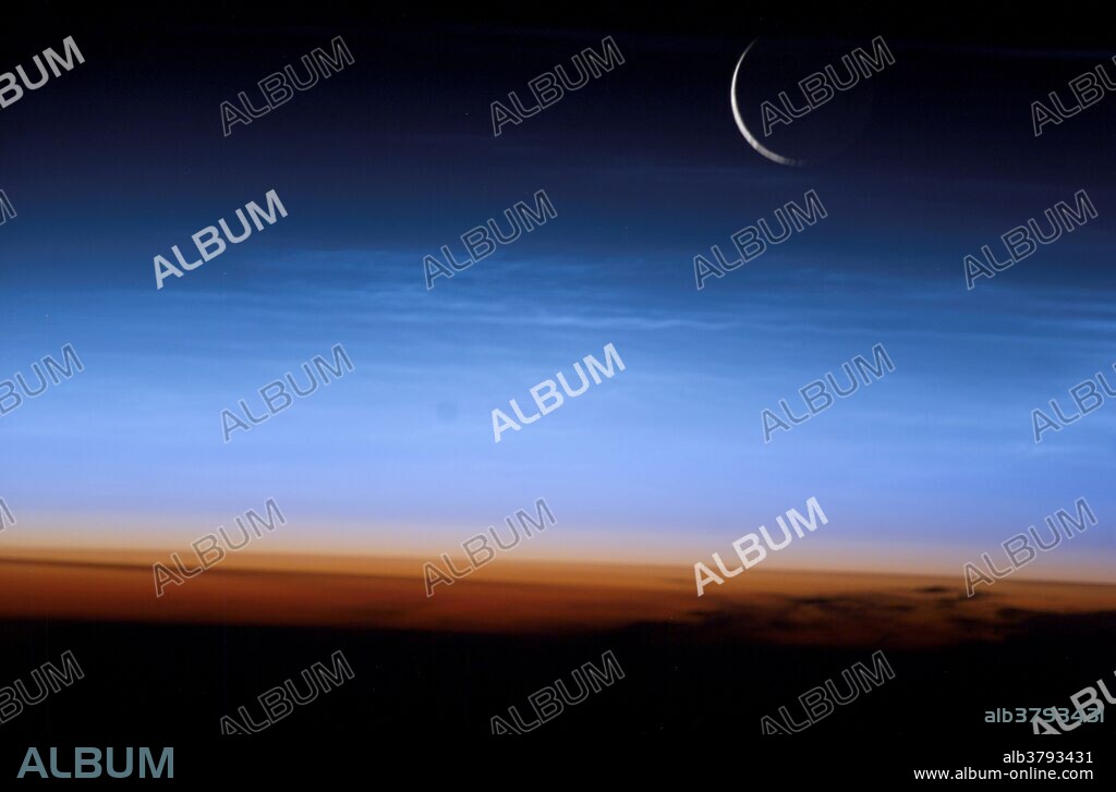 Noctilucent clouds and a setting crescent Moon, seen from the International Space Station. Noctilucent clouds are very high clouds that look like cirrus clouds, but are much higher than clouds that we observe every day. They are optically thin and can only be observed during twilight hours, when the sun is just below the horizon and only shines on the uppermost atmosphere. In this image, the limb of the Earth at the bottom transitions into the orange-colored troposphere, the lowest and most dense portion of the Earth's atmosphere. The troposphere ends abruptly at the tropopause, which appears in the image as the sharp boundary between the orange- and blue-colored atmosphere. The silvery-blue noctilucent clouds are far above this boundary. June to July is the season for noctilucent clouds in the northern hemisphere; they form in the polar mesosphere, generally above 50 degrees latitude. The lower three layers of the atmosphere (from bottom) are the troposphere (orange) and the stratosphere and mesosphere (pale blue). Above these, the atmosphere fades into the darkness of space. Photographed by astronaut Ed Lu on July 27, 2003, over Mongolia in central Asia.