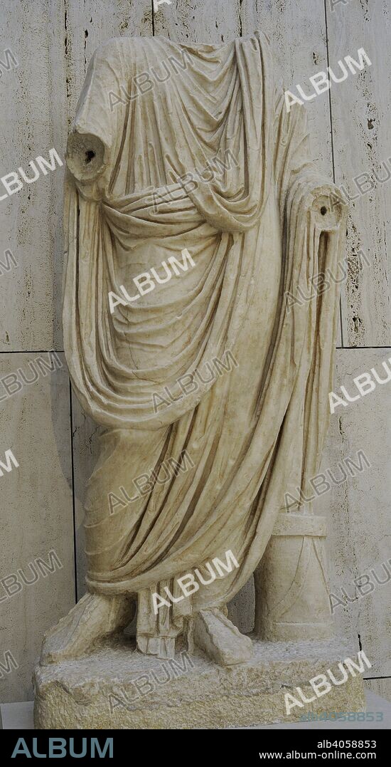 Togado. Estatua de un ciudadano notable, con toga y la caja de documentos escritos (volumina) a sus pies, que indica que fue un magistrado municipal. Siglo I. Estatua de mármol. Procedente del Foro de Baelo Claudia (Bolonia, provincia de Cádiz). Museo Arqueológico Nacional. Madrid. España.