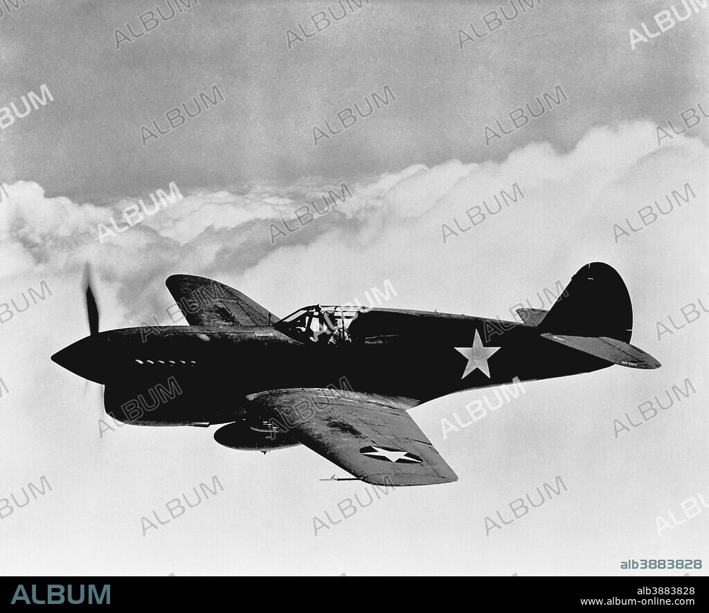 Vintage World War II photo of a P-40 fighter plane flying above the clouds.
