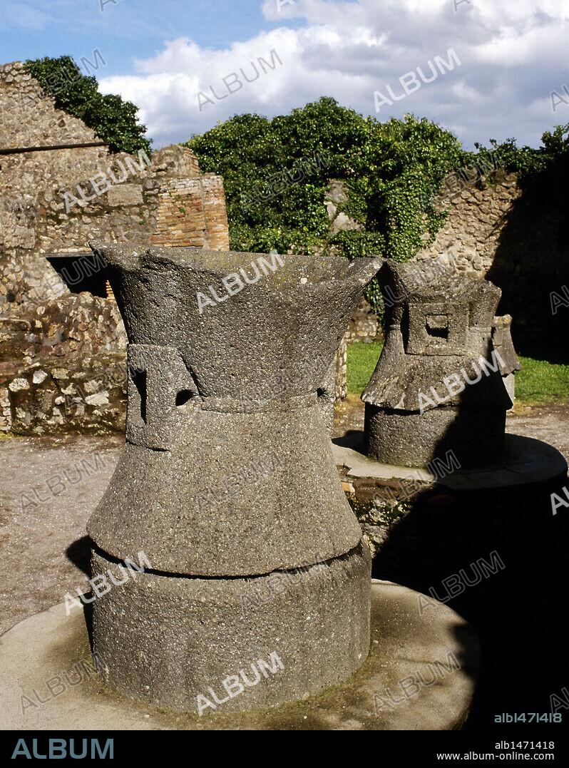 ARTE ROMANO. ITALIA. PANADERIA DE MODESTO. Estos establecimientos en época romana eran llamados "PISTRINUM". Detalle de una MUELA para moler el trigo. Cada muela se encuentra compuesta por dos partes en lava volcánica: una llena y cónica "meta" fija en una base y la honda y bicónica "catillus", que gira sobre la primera. POMPEYA. La Campania.