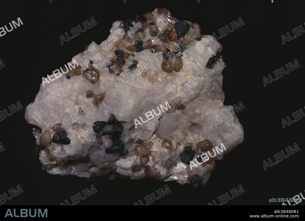 Willemite (brown) on quartz.  Willemite is a minor ore of zinc, and it glows green under ultraviolet light.