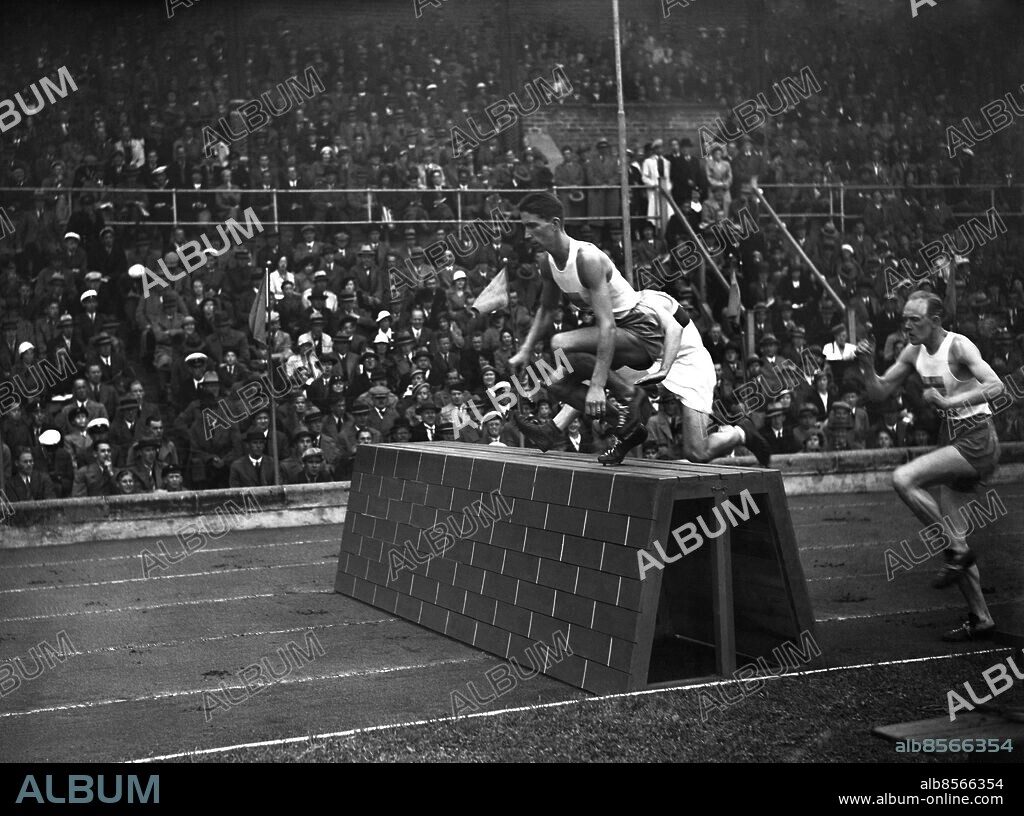 ARKIV 1934. Svensken Erik Larsson leder 3000 meter hinder i den klassiska landskampen mot Tyskland, som besegras för första gången. Sverige vinner med 101 1/3:s poäng mot 100 2/3. Svenskarna Erik Larsson och Frans Harry Ekman vinner dubbelt på hinder och i den avgörande stafetten på 4x400 meter vinner Sverige efter en heroisk insats av Bertil von Wachenfeldt på sista sträckan.. Sweden beats Germany in athletics for the first time. Picture shows Erik Larsson in first place in the steeple chase.. Foto: Scanpis Historical/1900. Scanpix Sweden.