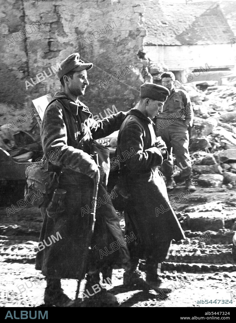 Nazi Prisoner limps to rear area : A German SS trooper captured on the Seventh U.S. Army front in France limps to the rear with the aid of a cane and a fellow Nazi. May 07, 1945. (Photo by U.S. Signal Corps Photo).