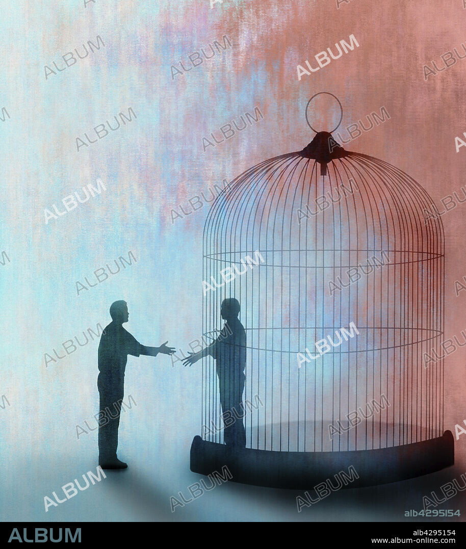 Man shaking hands with man trapped inside of cage.
