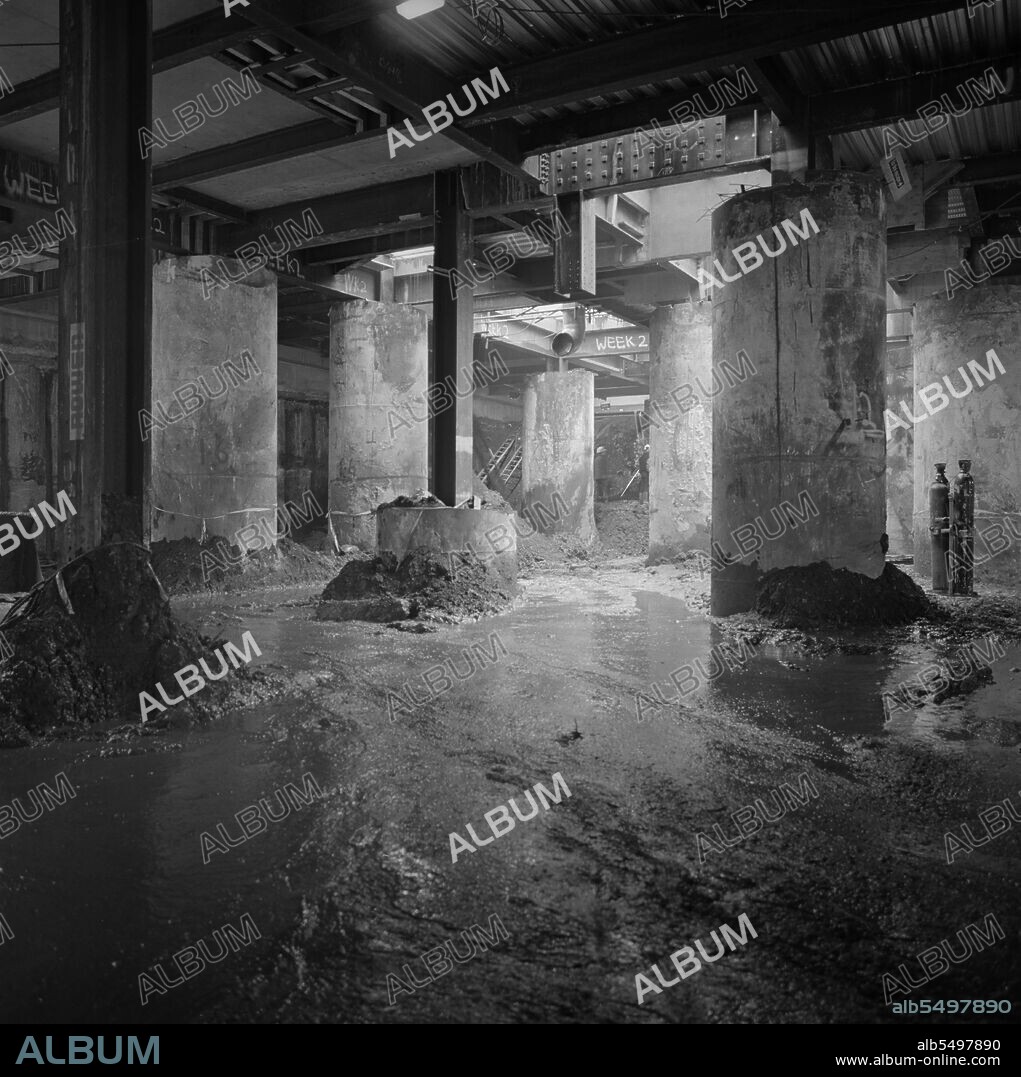 JOHN LAING PLC. Vintners Place, Upper Thames Street, Queenhithe, London, 30/04/1991. A view of the basement excavations below the transfer deck at Vintners Place showing the large diameter piles supporting the steel frame of the superstructure. Laing undertook the £79m management contract for the construction of a 37,000sqm high quality office development at Vintners Place between March 1989 and December 1992.  Work on site began in June 1989 with the demolition of 10 buildings including Vintry House and Kennet Wharf on the riverside.  The listed façade of Thames House along Queen Street Place was preserved and incorporated into the development.  The project was the first within the City of London in modern times permitted to reclaim land from the Thames foreshore for its riverside facade.  319 secant piles were bored for the perimeter foundation wall with 90 large diameter under-reamed piles for the main foundations and 84 contiguous piles within the coffer dam.