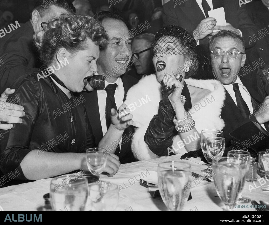 Orig. bildtext...CHEERS FOR OSCAR WINNERS NEW YORK....AT A NEW YORK NIGHT SPOT JUST AS NEWS CAME VIA RADIO FROM HOLLYWOOD OF ACADEMY AWARDS, WINNERS JUDY HOLLIDAY (LEFT) AND JOSE FERRER ARE CHEERED BY GLORIA SWANSON (RIGHT) WHO WAS A CONTENDER FOR THE COVETED AWARD. MISS HOLLIDAY WAS JUDGED THE YEAR'S BEST ACTRESS FOR HER ROLE IN BORN YESTERDAY AND FERRER'S PORTRAYAL OF CYRANO DE BERGERAC EARNED HIM THE ACADEMY AWARD AS 1950'S BEST ACTOR. GEORGE CUKOR IS SHOWN AT EXTREME RIGHT. Anm. Skådespelare Filmstjärnor Jubel Flor Leenden Armband Pälsstola Ansiktsuttryck Gapa CD282 persons: GEORGE CUKOR;GLORIA SWANSON;JOSE FERRER;JUDY HOLLIDAY sites: NEW YORK;USA.