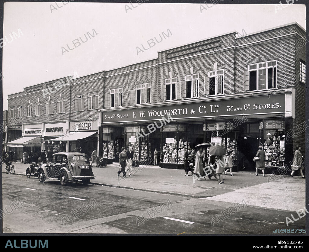 HEALEY AND BAKER. 130-150 George Lane, South Woodford, Redbridge, Greater London Authority, 1939-1950. The shopping parade at 130-150 George Lane, showing the shop front of F W Woolworth and Company Limited in the foreground, with people on the pavement.