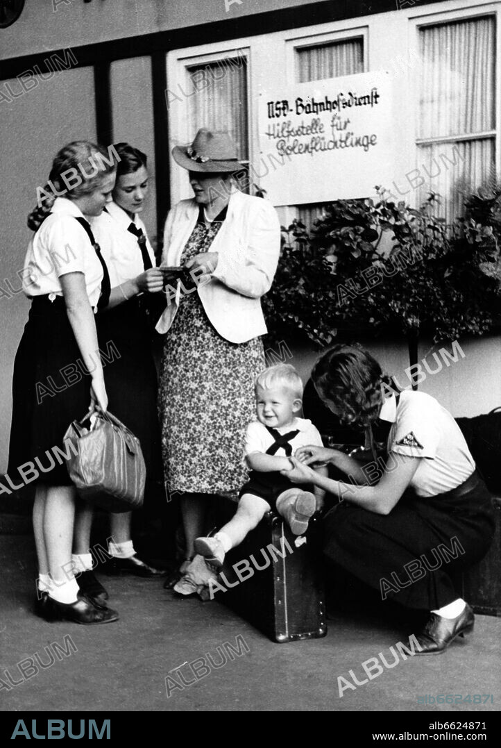 Girls of the German Girls League (BDM) help travelling women and children at the hitchhiker station in Berlin, in August 1939, in the station service of the National Socialist People's Welfare (NSV). Photo: Fotoarchiv für Zeitgeschichte/Archiv. 28/08/1939