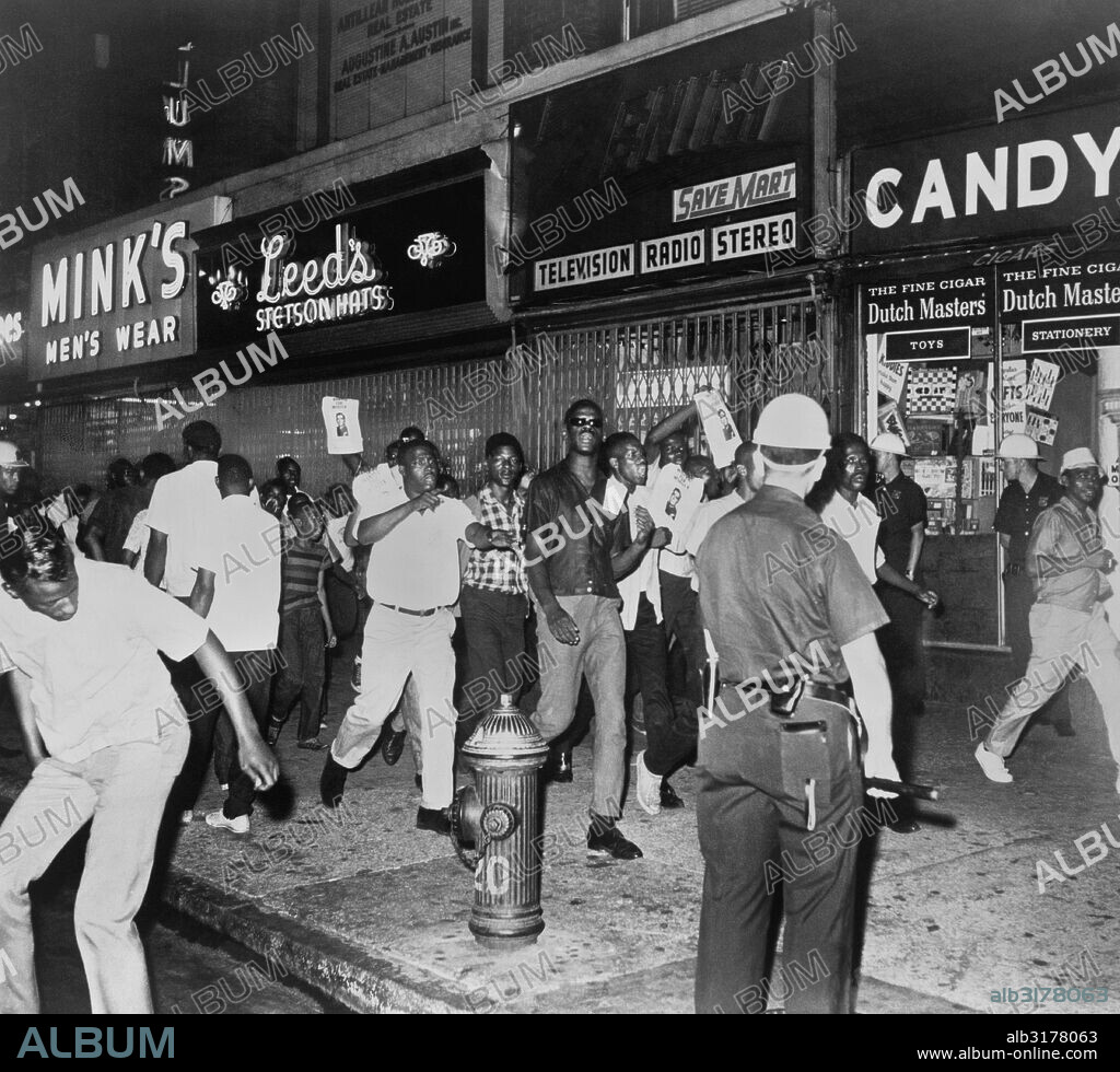 New York, New York:  1964 The fatal shooting of Harlem resident James Powell by NYPD Lieutenant  Gilligan stirred Negro rioters to race through Harlem streets carrying pictures of Lt. Gilligan.   © Underwood Archives / The Image Works.