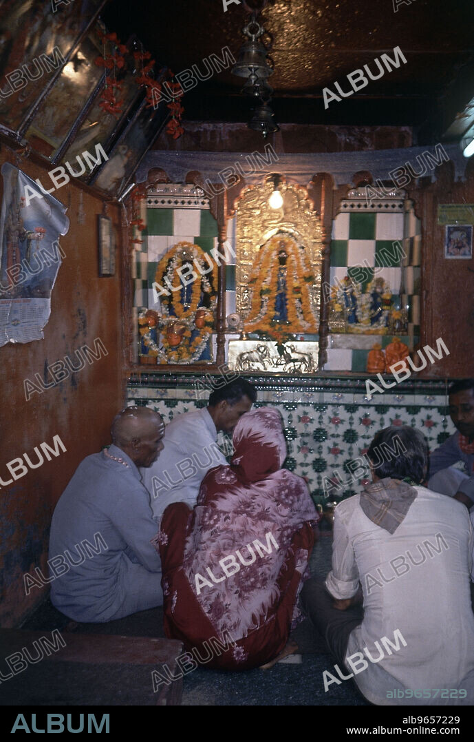 INTERIOR-AL FONDO ALTAR CON DIVINIDAD Y GENTE REZANDO.