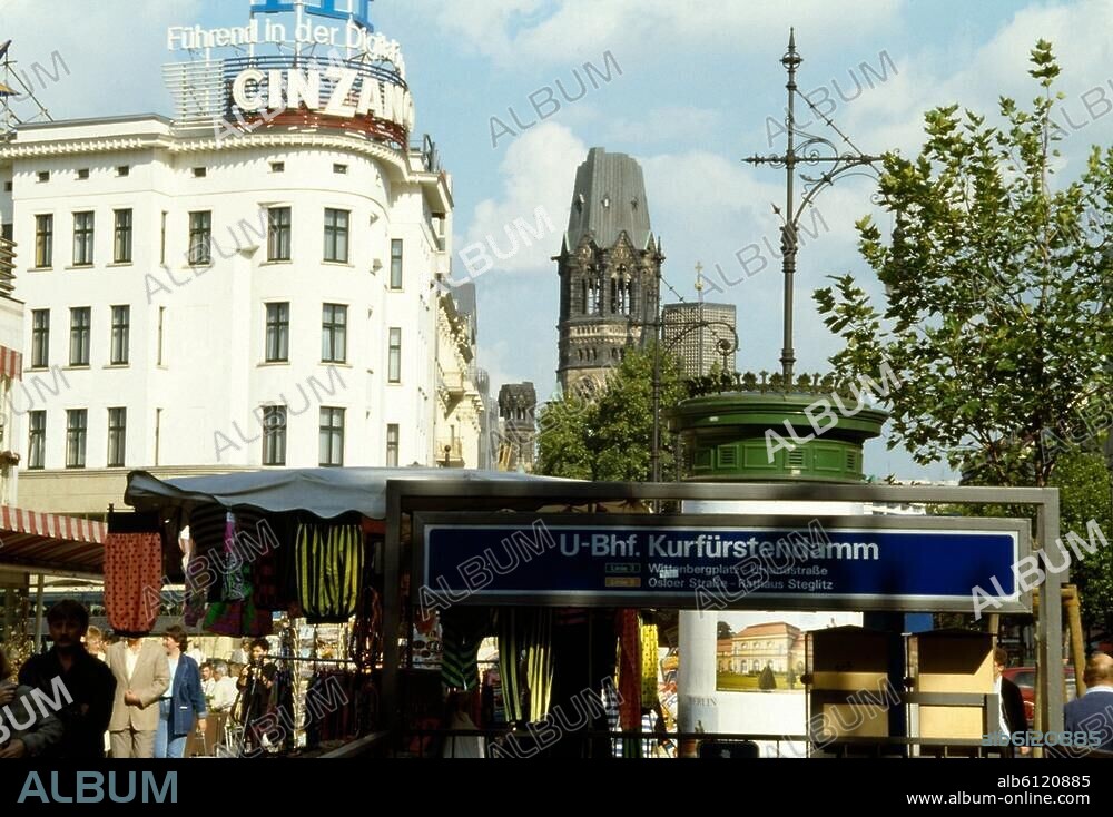 Berlin-Charlottenburg, Kurfürstendamm.-Straßensszene am Café Kranzler / Ecke Joachimstaler Straße mit Blick auf den Eingang zum U-Bahnhof Kurfüstendamm und die Kaiser-Wilhelm-Gedächtniskirche im Hintergrund.-Foto, undat. (um 1988/89).