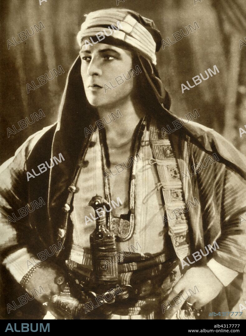 Rudolph Valentino in "The Sheik", 1921, (1935). Portrait of Rudolph Valentino (1895-1926), film actor born in Italy, one of the first 'Hollywood heartthrobs'. Valentino arrived in the United States in 1913 and found fame as a film star and sex symbol of the 1920s. When he died at the age of 31, of complications after surgery for appendicitis and gastric ulcers, 100,000 people lined the streets of Manhattan in New York to pay their respects at his funeral. From "The Silver Jubilee Book - The Story of 25 Eventful Years in Pictures". [Odhams Press Ltd., London, 1935].
