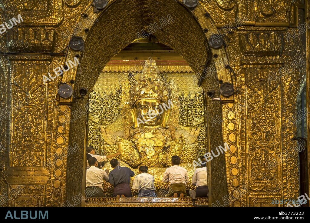 Saint golden Buddha in Mahamuni Pagoda, locals praying, Mandalay, Myanmar, Asia.