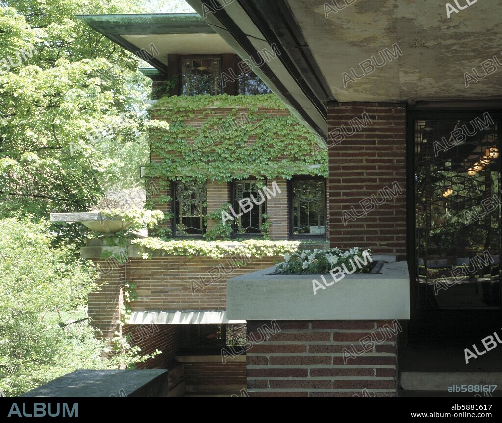 FRANK LLOYD WRIGHT. ROBIE HOUSE, PRIVATE HOUSE (1909) ROBIE HOUSE, PRIVATE HOUSE EXTERIOR VIEW FROM STEPS TOWARDS IVY CLAD WALL.