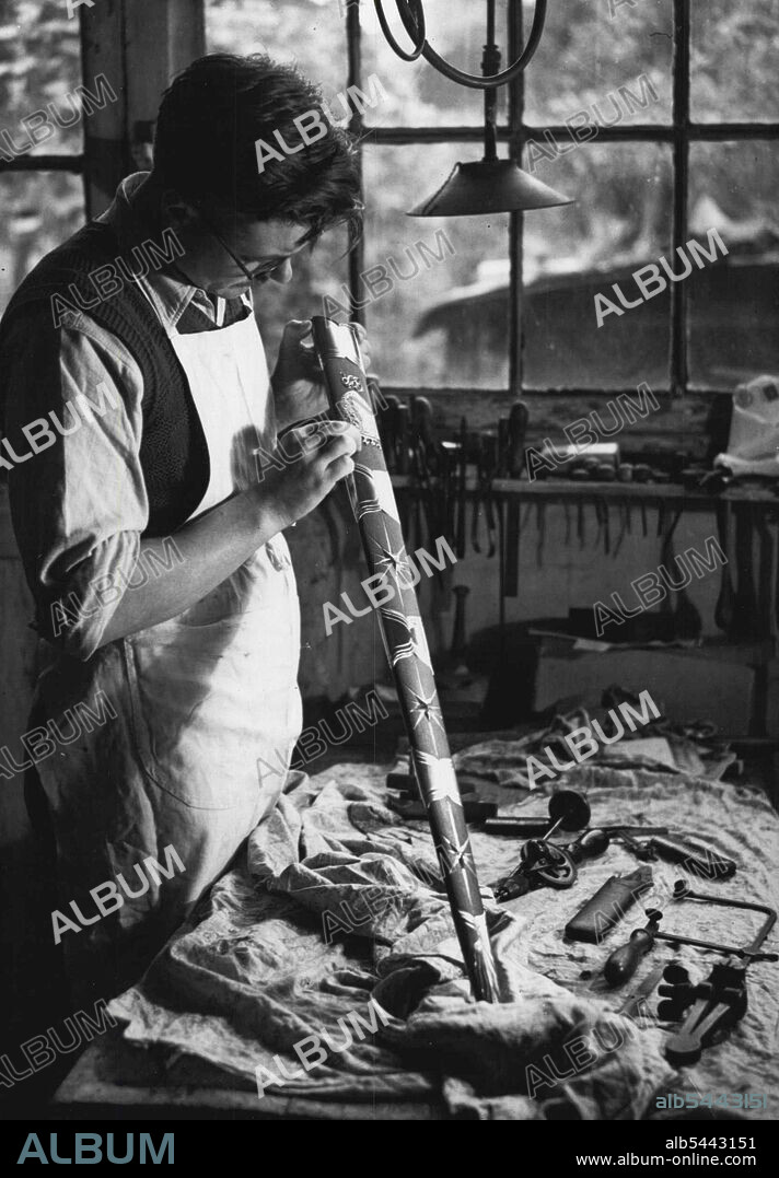 The Stalingrad Sword. Picture Show: The Royal Coat of Arms and Lonogram and the Russian Stars, which decorate the soabbard. Holding the soabbard is Mr. L.G. ***** responsible for the gold and silver ***** on the soabbard. Putting The Finishing Touches To The King's Gift To The "Steel-Hearted Citizens of Stalingrad". The Two-Handed sword of Honour. to be presented ***** His Majesty the King to Stalingrad is now Completed and on View at the Goldsmith's Hall. These Pictures show the experts who have made it. ***** the finishing touches. January 03, 1943. (Photo by I.N.A.).