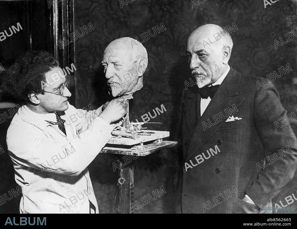 TYSKLAND BERLIN 1930-tal.. Orig. bildtext... EINE PIRANDELLOBÜSTE Luigi Pirandello, der anlässlich der Aufführung seiner Stücke in Berlin weilt, lässt sich von dem Berliner Bildhauer modellieren. Unser Bild zeigt rechts den bekannten italienischen Dramatiker Luigi Pirandello mit der von dem Berliner Bildhauer K. Harald Isenstein geschaffenen Büste und dem Bildhauer. Orig. bildtext... PIRANDELLO NOBELPRISTAGARE I LITTERATUR. 1934 års Nobelpris i litteratur har tilldelats Luigi Pirandello. Vår bild visar: Pirandello står modell för skulptören Harald Isenstein. Anm. L Pirandello, 1867-1936, italiensk författare och dramatiker. Nobelpriset i litteratur 1934. K H Isenstein, 1898-1980, tysk skulptör, från 1934 bosatt i Danmark och Sverige pga politisk förföljelse i hemlandet. Byst Fluga Handen i fickan Mustasch Skägg Trio CD570 persons: LUIGI PIRANDELLO;KURT HARALD ISENSTEIN sites: ITALIEN*;BERLIN;TYSKLAND.