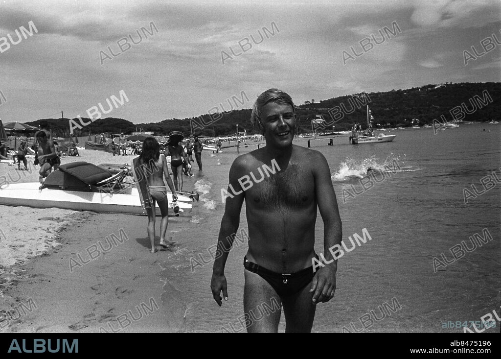 ARKIV SAINT-TROPEZ 196908.. Sven-Bertil Taube, skådespelare och sångare, promenerar på stranden vid Saint-Tropez på den franska rivieran.. Foto: Ulf Stråhle / SVT / Kod: 5600. Reportage publ. i RiR 37/69 inför TV:s deckarkomedi "Håll polisen utanför.". RiR 19637. sv/v neg. Bar överkropp Badbyxor.