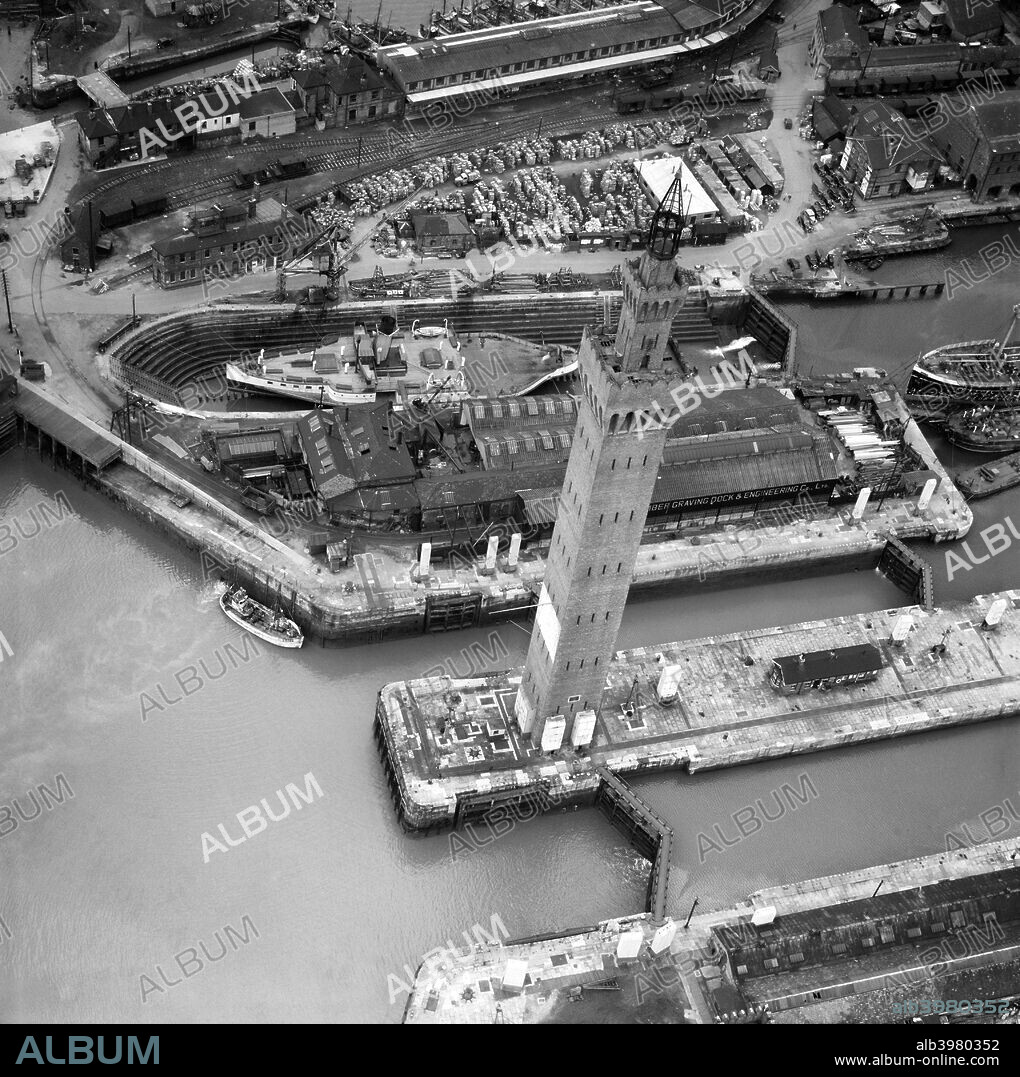 Grimsby Dock Tower, Lincolnshire, April 1950. This famous maritime landmark was built in 1852 as a hydraulic reservoir to power the lock gates and cranes of Grimsby Docks. Based on the design of the Palazzo Pubblico in Siena, the tower is 94m tall. By 1900 new technology made it largely redundant, but it remains a monument to Grimsby's maritime heritage. There is a model of the tower at Legoland, Windsor. The paddle steamer Lincoln Castle can also be seen in Alexandra Dock in this aerial photograph.