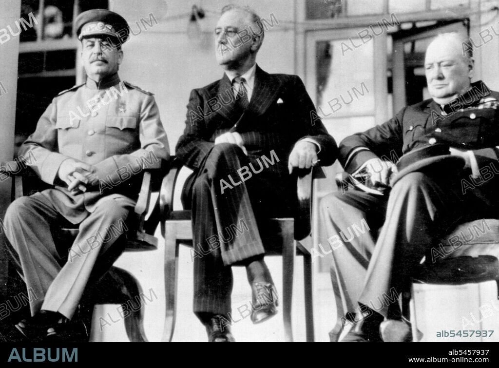 Principals At Teheran Conference -- Joseph Stalin, Russian premier (left), sits with President Franklin D. Roosevelt of the United States and Prime Minister Winston Churchill (right), on the porch of the Russian Embassy at Teheran, Iran, during their four-day conference at which they drew plans to concentrate the total military might of Russia, United States and Britain on a "Relentlessly Increasing" Basis Guaranteeing victory over Germany. This is one of a series of photos on the conference made by U.S. Army 12th Air Forces photographers and pleased by the War Department in Washington. December 05, 1943. (Photo by Associated Press Photo).