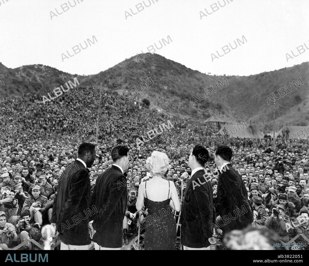 Captioned: "Marilyn Monroe sings several songs for an estimated 13,000 men of the First Marine Division. Miss Monroe stopped by at the First Marine Regiment on her tour of the military units in Korea." In the 1940s the USO was disbanded due partly to lack of funds. However, in 1950, when the United States entered the Korean War, Secretary of Defense George Marshall and Secretary of the Navy Francis P. Matthews requested that the USO be reactivated. Many stars, both well-known and new, came to perform. Marilyn Monroe (June 1, 1926 - August 5, 1962) was an American actress, model, and singer, who became a major sex symbol, starring in a number of commercially successful motion pictures during the 1950s and early 1960s. She travelled to Korea where she performed for 13,000 American Marines over a three day period. By the end of the war, over 113,000 American USO volunteers were working at 294 centers at home and abroad. Photograph credited to Corporal Kreplin, USMC, February 16, 1954.