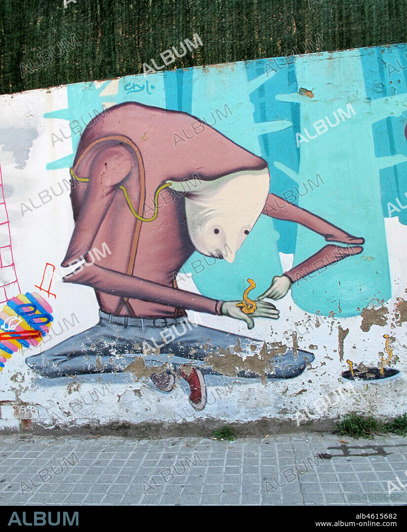 Ilustración de personaje surrealista jugando con una lombriz en sus manos, graffiti mural, carrer del Llobregós, distrito Horta Guinardó, Barcelona en 2013.