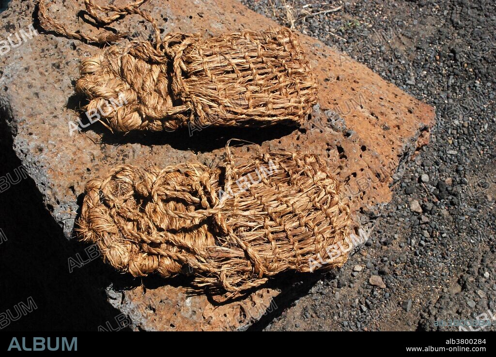 Pair of sagebrush bark sandals modeled after ancient sandals found in Fort Rock Cave in the 1930s and dated to more than 9,000 years old. 75 such sandals were recovered from the site buried under copious amounts of volcanic ash from the eruption of Mt. Mazama which formed Oregon's famous Crater Lake. The sandals are still the oldest footwear ever found.