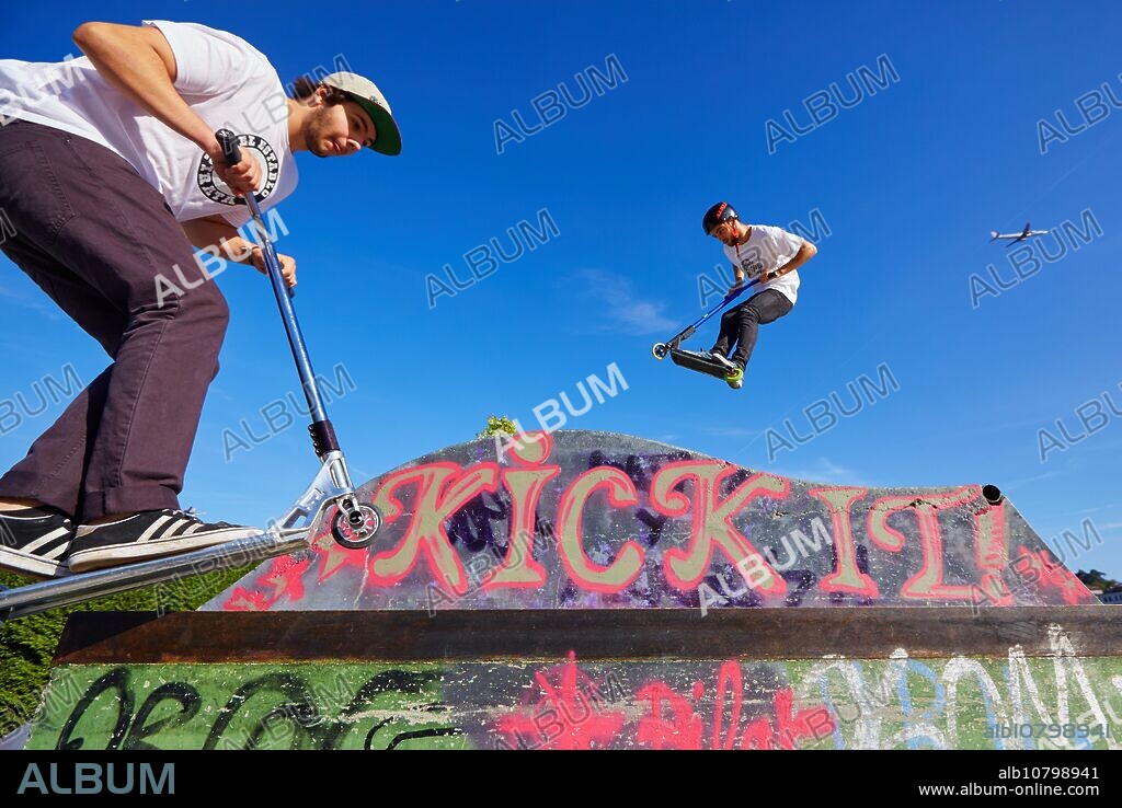 Teenager with city scooter in Skate park, Leioa, Bizkaia, Basque Country, Spain.