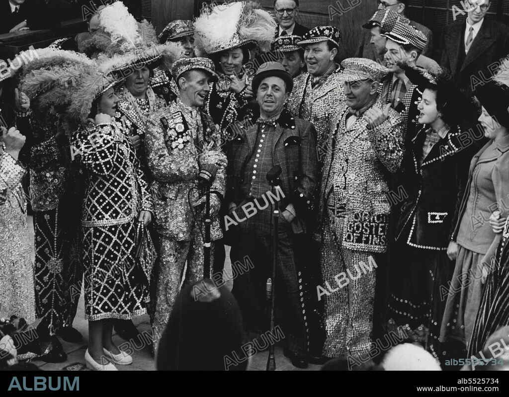 Doing The "Lambeth Walk." Lupino Lane At Pearlies Pub Re-Naming - With hands in pockets and wearing "Me and My Gal" costume, actor Lupino Lane joins London's Pearly Kings and Queens in singing the "Lambeth Walk" after a ceremony at which the "Mason Arms"- public house - at the corner of Lambeth Walk and China Walk (South East London) - had been renamed 'The Lambeth Walk.'Mr. J. Marriott, the Pearly King of Finsbury performed the re-naming ceremony,,Other Pearly Kings, and Lupino, he made the Lambeth Walk song and dance famous in the "Me and My Gal" show, attended. April 03, 1951.
