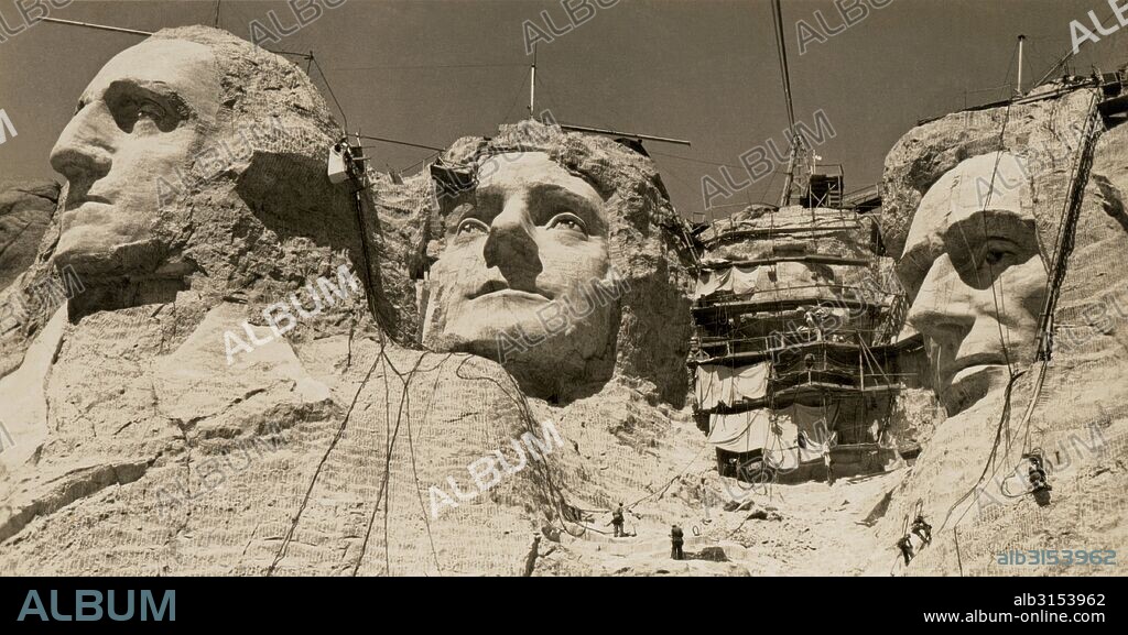 Mt. Rushmore, South Dakota:  c. 1938. Workmen on the faces of Mount Rushmore.  Roosevelt has the scaffolding over his face.