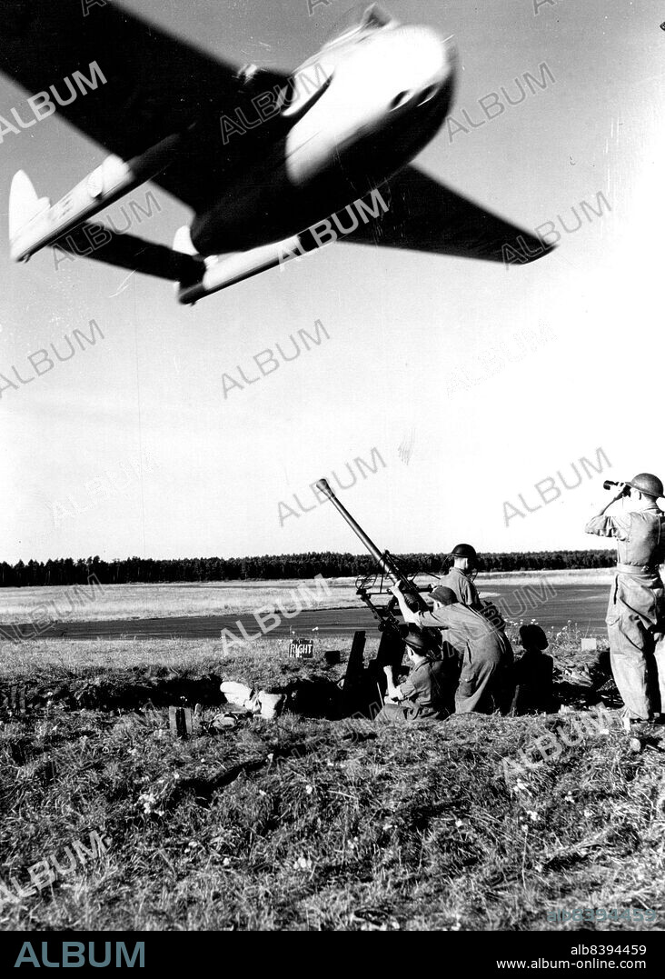 Low Level Attack -- Group captain "Teddy" Donaldson making an extremely low-level mock attack on an anti-craft gun position.  Group captain Donaldson is a specialist in this form of attack and when this photo was taken he may not have been more than 15 feet above the gun and was travelling at about 450 M.P.H. It was group captain Donaldson who broke the world's air speed record in a meteor in 1946.Army and Royal Air force manoeuvres in Germany are continuing in the exercise known as operation "Holdfast". September 18, 1952. (Photo by Paul Popper, Paul Popper Ltd.).