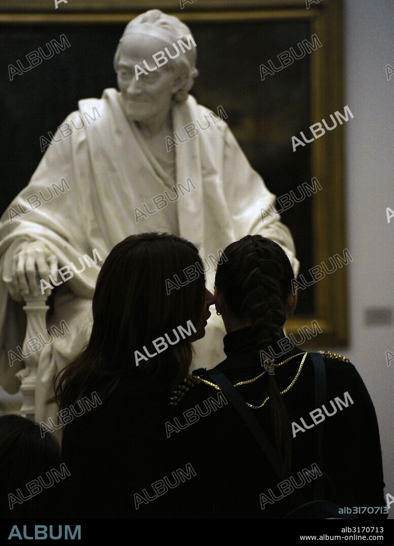 Jóvenes contemplando la estatua de Voltaire (1694-1778) en el interior del Museo del Hermitage (The State Hermitage Museum). San Petersburgo. Rusia.