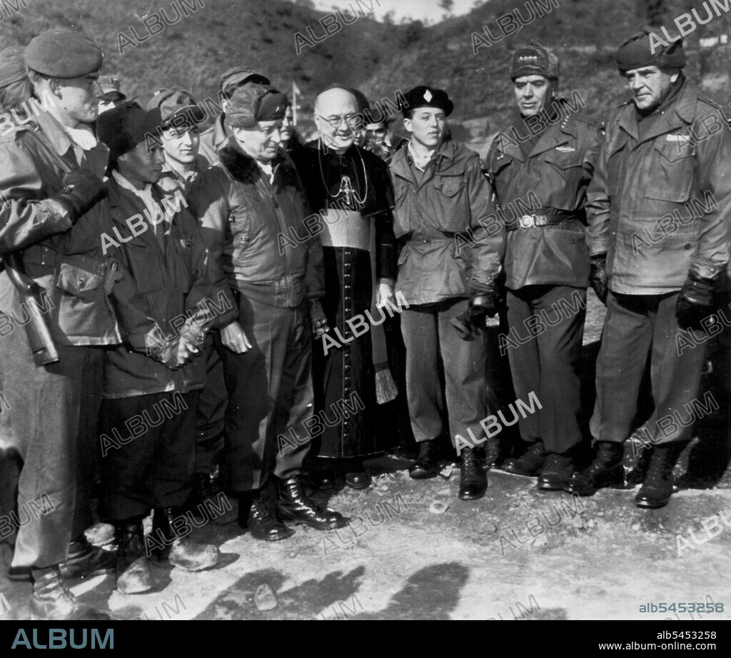 Cardinal Spellman With Un Troops -- Francis Cardinal Spellman (center) and Gen. James Van Fleet, 8th army commander (second from right) pose with 2d Division GIs and members of the French Battalion after a Catholic Christmas service somewhere in Korea. It was the second successive Christmas spent by the Cardinal in Korea. December 27, 1952. (Photo by AP Wirephoto).