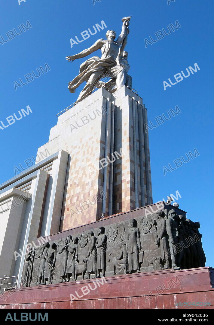 Worker and Kolkhoz Woman sculpture in Moscow, depicts of two figures with a sickle and a hammer raised over their heads. It is 24.5 meters (78 feet) high, made from stainless steel by Vera Mukhina for the 1937 World's Fair in Paris and subsequently moved to Moscow. The sculpture is an example of the socialist realistic style, as well as Art Deco style. The worker holds aloft a hammer and the kolkhoz woman a sickle to form the hammer and sickle symbol.