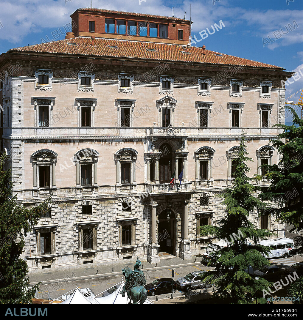 Palazzo Cesaroni, by Guglielmo Calderini, 1898-1900, 19th Century,. Italy, Umbria, Perugia, Perugia, Palazzo Cesaroni. Palazzo Cesaroni facade cornice string course balcony windows trees doorway roof road lane.