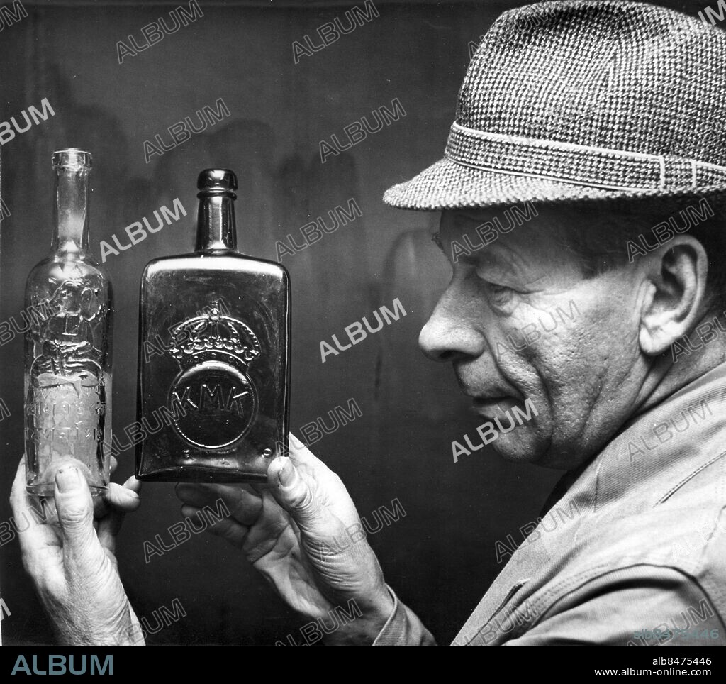 SURTE 1962-11-20.. Surte glasbruk - förman Helge Hagström visar en vinbutelj med en kinesisk gud samt en Whiskybutelj, som på 1920-talet beställdes av Kungliga Motorbåtsklubben. *** Local Caption *** GT - Foto: Alf Weihed / Kamerareportage / TT / Kod: 2524.