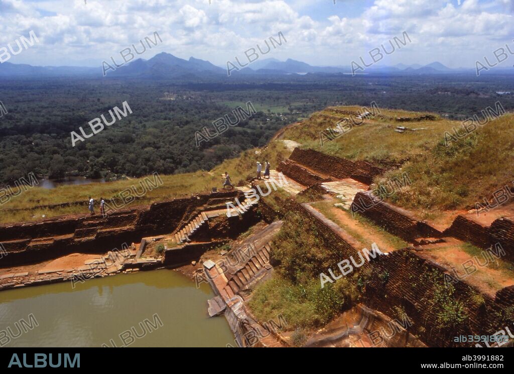 View from the Top of the Rock Fortress, Sigiriya, Sri Lanka, 20th century. Sigiriya is an ancient rock fortress of historic and archaeological significance, located in the central Matale District in the Central Province of Sri Lanka.  According to the ancient Sri Lankan chronicle the Culavamsa, this site was selected by King Kasyapa (477-495 CE) for his new capital. He built his palace on top of this rock and decorated its sides with colourful frescoes.