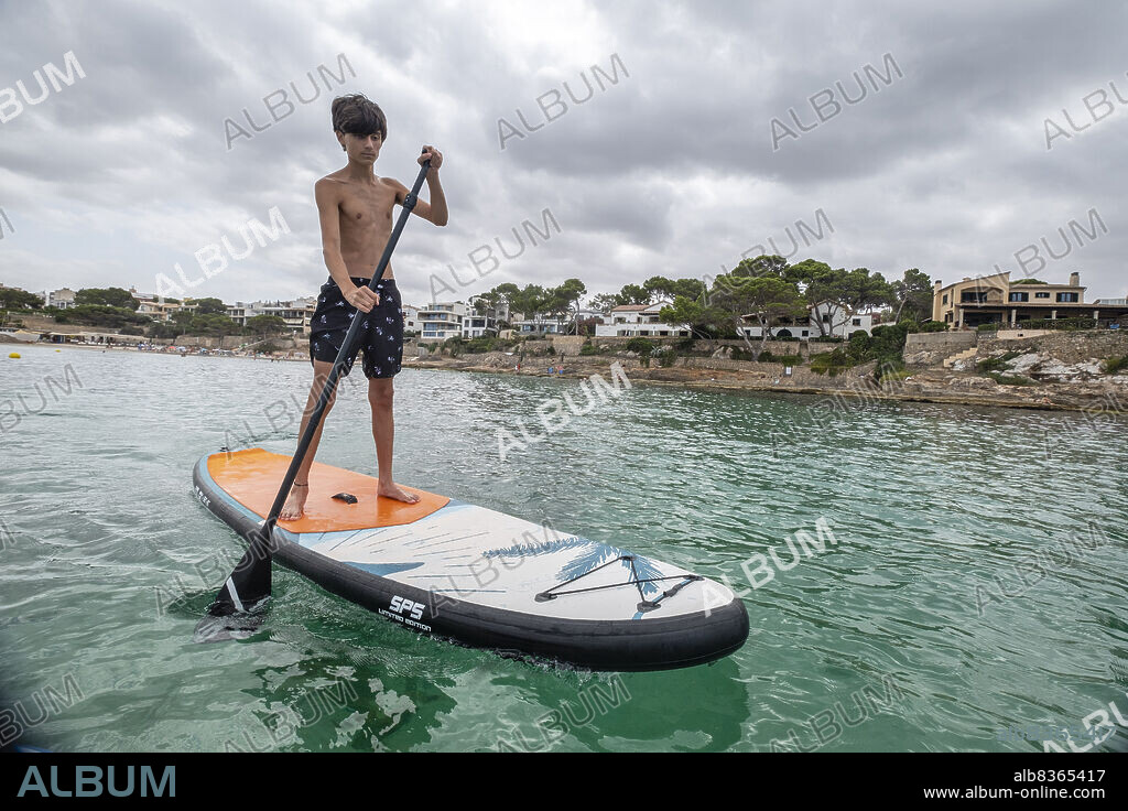 Paddle surfing in the Caló de Sant Antoni, S Arenal de Llucmajor, Mallorca, Balearic Islands, Spain.