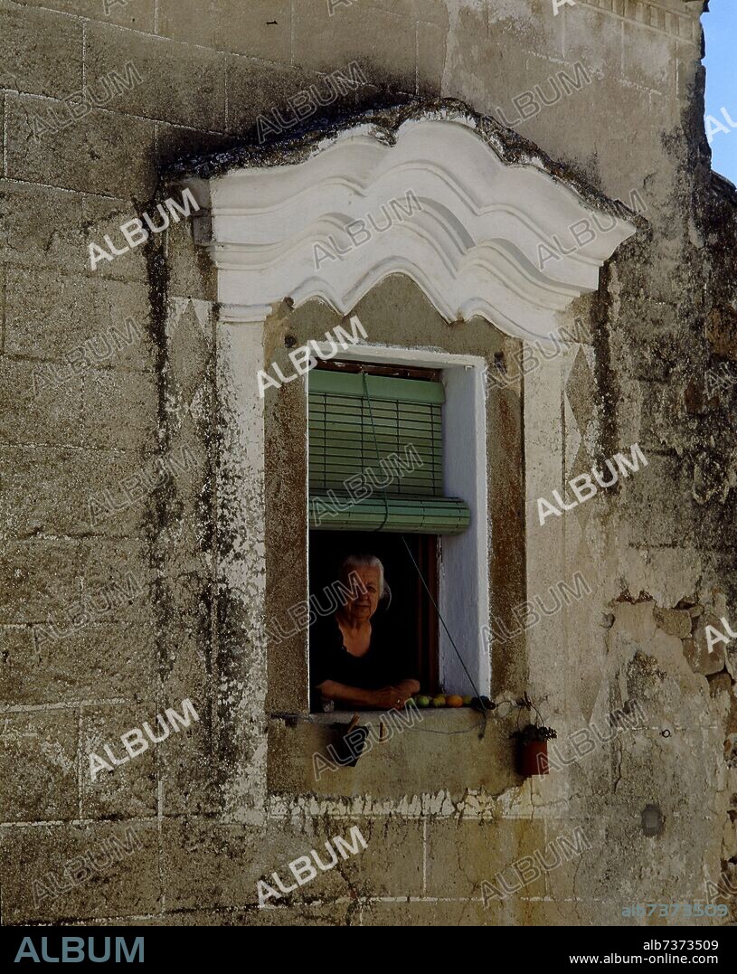 VENTANA CON UNA SEÑORA ASOMADA.