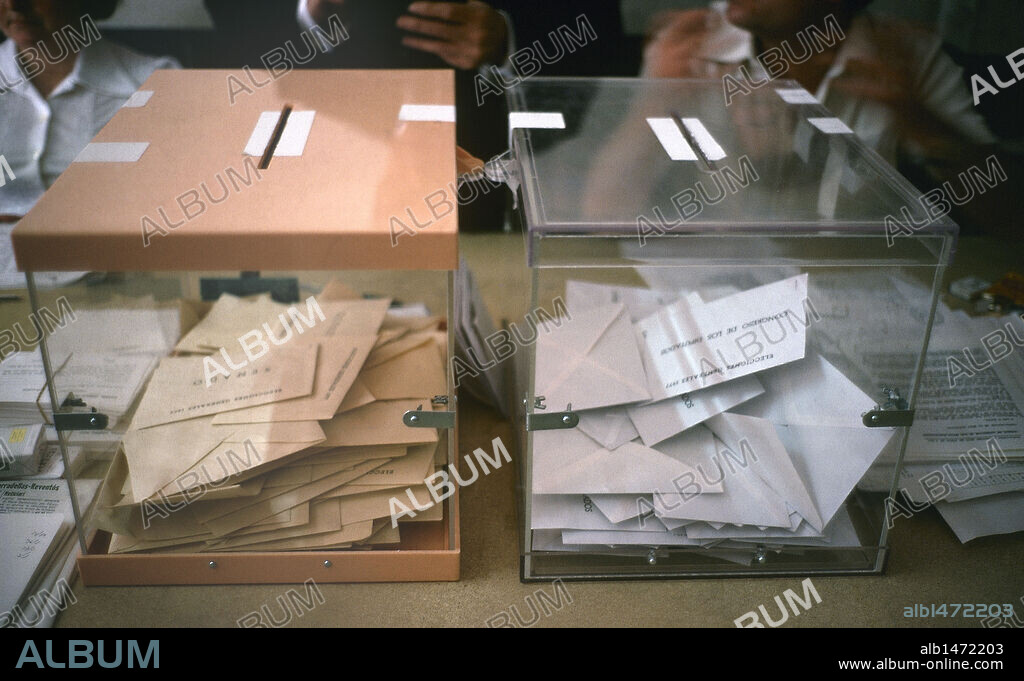 ELECCIONES GENERALES DE 1977 (15 DE JUNIO). La campaña electoral para la elección de las nuevas Cortes se desarrolló entre el 24 de mayo y el 13 de junio. Triunfaron UCD y PSOE. Las nuevas Cortes (22-7-77) empezaron a redactar una Constitución y Suárez formó nuevo Gobierno con mayoría de UCD (5-7-77). DETALLE DE LAS URNAS EN UNA MESA ELECTORAL.
