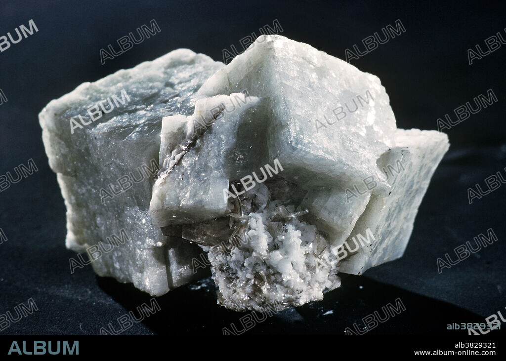 Dolomite, calcium magnesium carbonate, is a common mineral that occurs throughout the world. Thick beds of dolomite were produced by the alteration of limestones (made of calcite, calcium carbonate) by magnesium-rich hot solutions, a process called 'dolomitization'. Dolomite forms good crystals in veins in ore deposits. Crystals also occur in open spaces within massive dolomite beds, such as the specimens recovered from the Simplon Tunnel in Switzerland. Both dolomite and calcite typically form crystals with a characteristic rhomb shape.