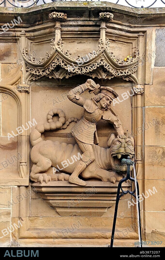 High-relief of St. George and the Dragon as a well figure on the Gothic Fischbrunnen fountain, built in 1509 by the Haller sculptor Hans Beuscher, Marktplatz square, Schwäbisch Hall, Baden-Wuerttemberg, Germany, Europe, PublicGround, Europe.
