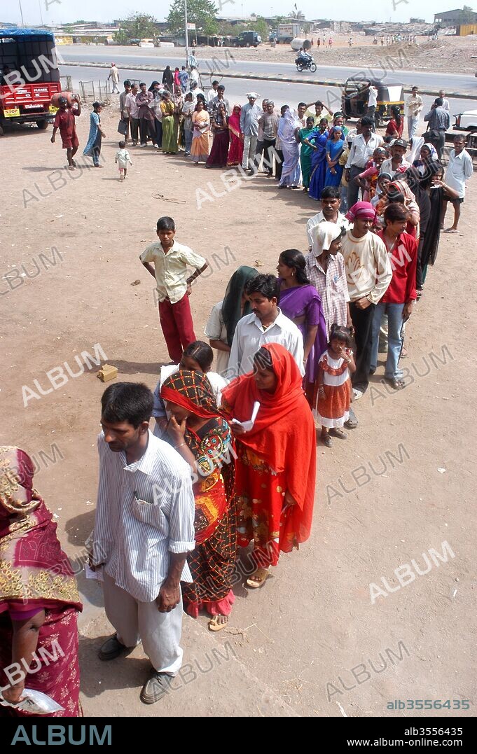 A queue outside a polling station at Mankhurd ; in the Eastern suburb of Bombay ; now Mumbai city ; Maharashtra ; India during the recent Lok Sabha election ; after which Congress party formed the government under the leadership of Dr Man Mohan Singh ; who is first Sikh to become the Prime Minister of the country.