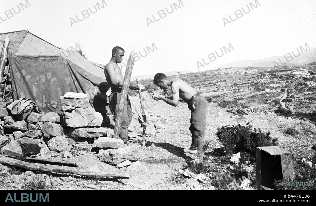 España. Guerra civil (1936-1939). Falange española y de las J.O.N.S. División 72 del Cuerpo del Ejército de Castilla. Flechas Verdes, junto a legionarios del Corpo Truppe Volontaire, CTV, formaron una unidad mixta italo-española movilizada para hacer frente en la ofensiva de Catalunya al final de la contienda. Dos soldados aseándose en un campamento en los montes de la zona de Ávila.